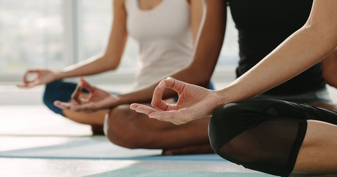 People sitting and doing yoga with hands in om position